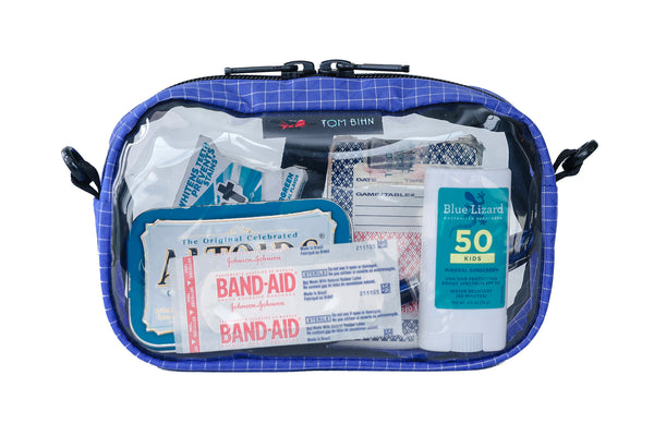 A Selkie (purplish-blue with white grid pattern) Halcyon 3D Clear Organizer Cube filled with sundries.